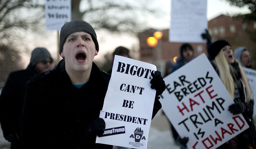 Logun Buckley, left, a senior at the University of Northern Iowa, protests against Republican presidential candidate Donald Trump on the school&#x27;s campus, Tuesday, Jan. 12, 2016, in Cedar Falls, Iowa, where Trump is scheduled to hold a rally. (AP Photo/Jae C. Hong)