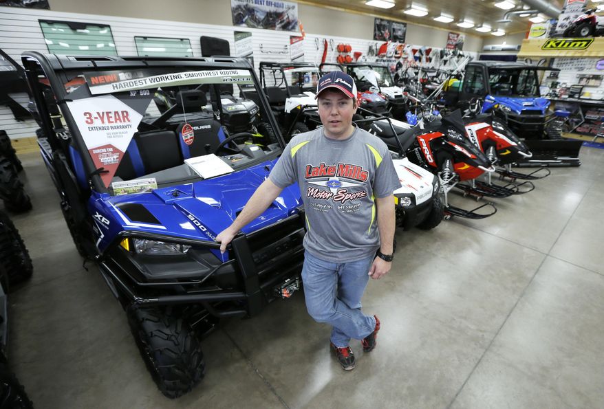 In this Dec.16, 2015 photo, Michael Rygh stands near all-terrain vehicles at his dealership in Algona, Iowa. The buzzy, open-air vehicles are supposed to be banned from roads in New York and other states. But small communities across the nation are increasingly bending the rules under pressure from riders who want to go wherever they please, even though ATV manufacturers warn that the vehicles are unstable on flat pavement and accidents kill more than 300 riders each year. (AP Photo/Charlie Neibergall)