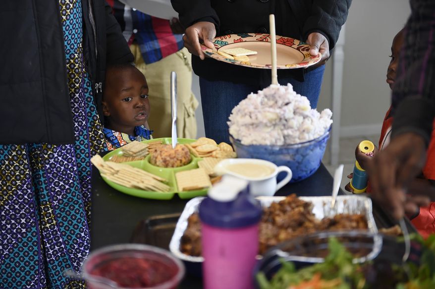 ADVANCE FOR WEEKEND EDITIONS JAN. 16-17 - In this Nov. 26, 2015 photo, Daniel Mulabwe looks at all the food during Thanksgiving Day dinner at the Bangerter's home in Twin Falls, Idaho. After three years of awaiting approval, Kanegamba Mulabwe, 26, Bahati, 22, and their children, Sarah, 3, and Daniel, 1, passed security checks and were approved to come to the U.S. (Drew Nash/The Times-News via AP) MANDATORY CREDIT