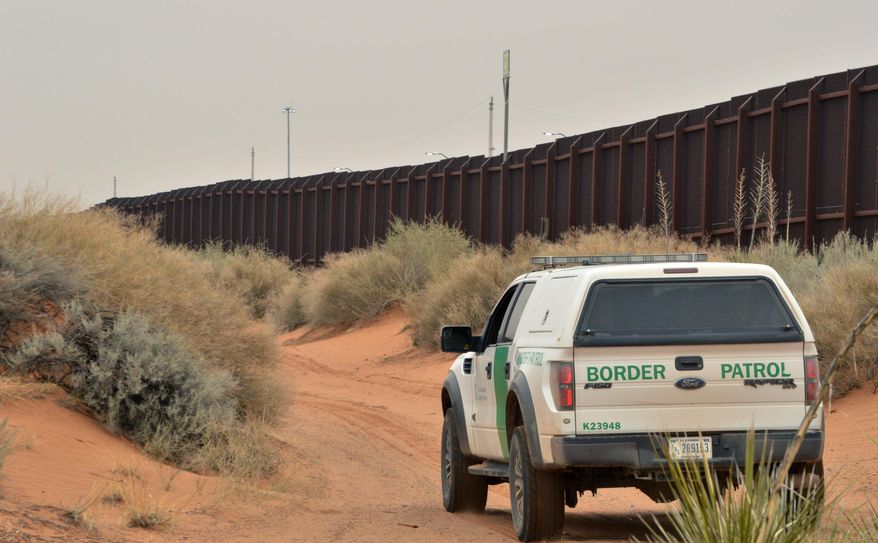 In this Jan. 4, 2016 photo, a U.S. Border Patrol agent drives near the U.S.-Mexico border fence in Santa Teresa, N.M. A spike in families and children arriving at the U.S. southern border from Central America has prompted fears of another crisis like the one that dominated national news during the summer of 2014. (AP Photo/Russell Contreras)