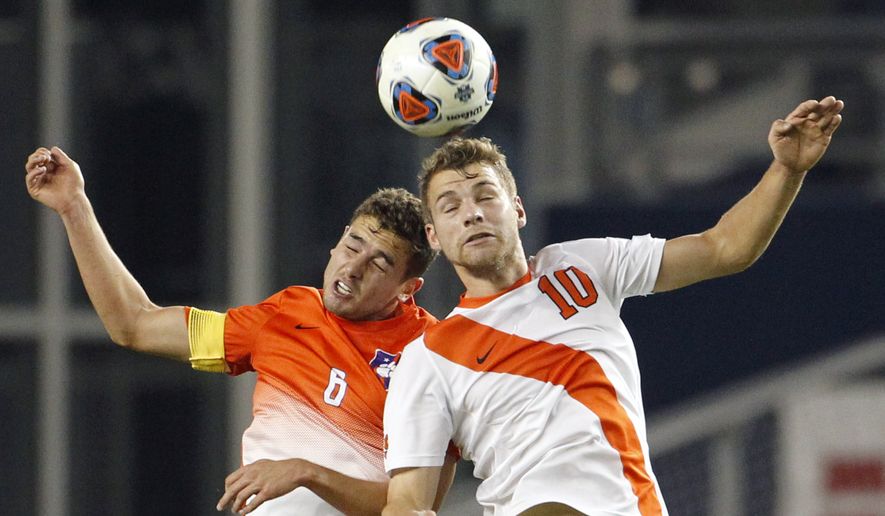 Clemson midfielder Paul Clowes (6) and Syracuse midfielder Julian Buescher (10) go up for the ball in the first half of an NCAA College Cup soccer match, Friday, Dec. 11, 2015, in Kansas City, Kan. (AP Photo/Colin E. Braley)