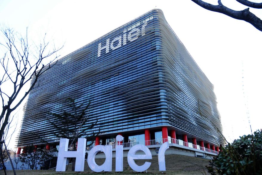 In this March 20, 2014 photo, a sign with the Haier logo stands in front of the company's headquarters in Qingdao in eastern China's Shandong province. Haier Group, the world’s biggest home appliance maker, announced Friday, Jan. 15, 2016, that it is buying General Electric Co.’s appliance business for $5.4 billion to expand its U.S. and global presence. (Chinatopix via AP) CHINA OUT