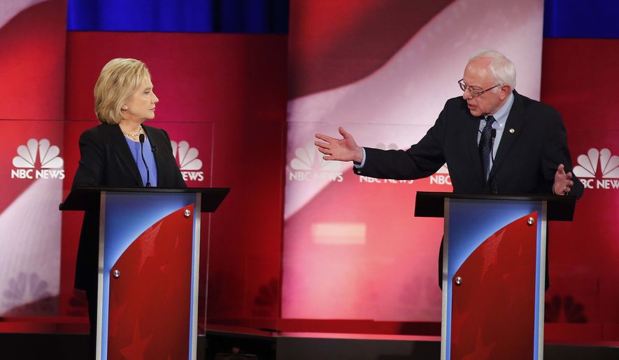 Democratic presidential candidate, Sen. Bernie Sanders, I-Vt.,  gestures towards Democratic presidential candidate, Hillary Clinton during the NBC, YouTube Democratic presidential debate at the Gaillard Center, Sunday, Jan. 17, 2016, in Charleston, S.C. (AP Photo/Mic Smith)