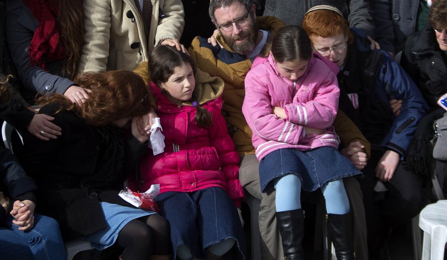 The family of Israeli Dafna Meir attend her funeral at a cemetery in Jerusalem Monday, Jan. 18, 2016. A Palestinian attacker stabbed and wounded a pregnant Israeli woman in the West Bank before being shot, Israeli officials said. (AP Photo/Sebastian Scheiner)