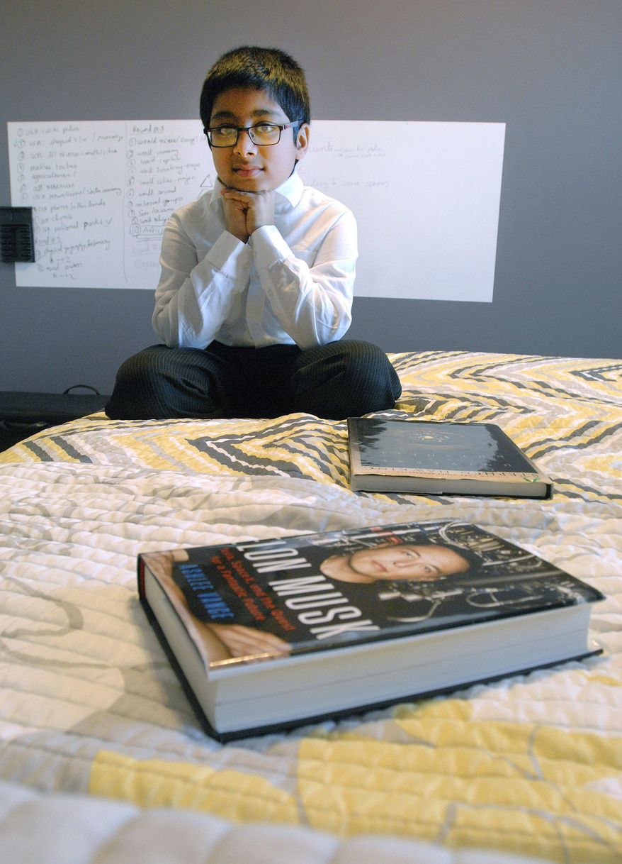 In this Jan. 2, 2016 photo, Vivek Abraham poses for a photo in the bedroom of his home in Bloomington, Ill. Abraham is considered a child genius with an IQ score of more than 160; the average is between 85 and 114. He is inspired by a variety of scientists and entrepreneurs, like Elon Musk, who founded SpaceX. (David Proeber/The Pantagraph via AP)