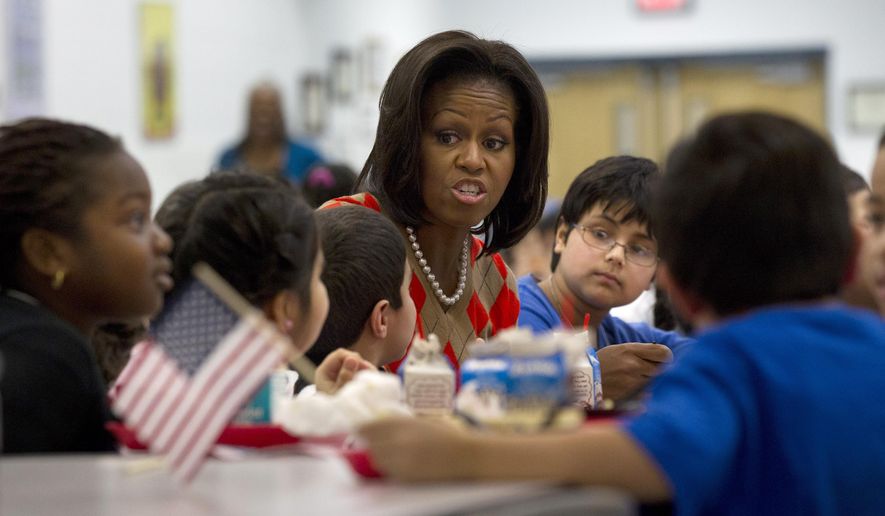 FILE - In this Jan. 25, 2012 file photo, First lady Michelle Obama has lunch with school children at Parklawn elementary school in Alexandria, Va. A bipartisan Senate bill released Monday would revise healthier meal standards put into place over the last few years to give schools more flexibility in what they serve the nation's schoolchildren, easing requirements on whole grains and delaying an upcoming deadline to cut sodium levels on the lunch line. (AP Photo/Pablo Martinez Monsivais)