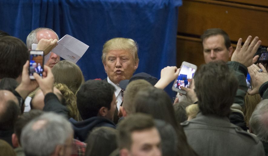 Republican presidential candidate Donald Trump, top center, blows a kiss to a supporter during a campaign stop at Concord High School, Monday, Jan. 18, 2016, in Concord, N.H. (AP Photo/John Minchillo)