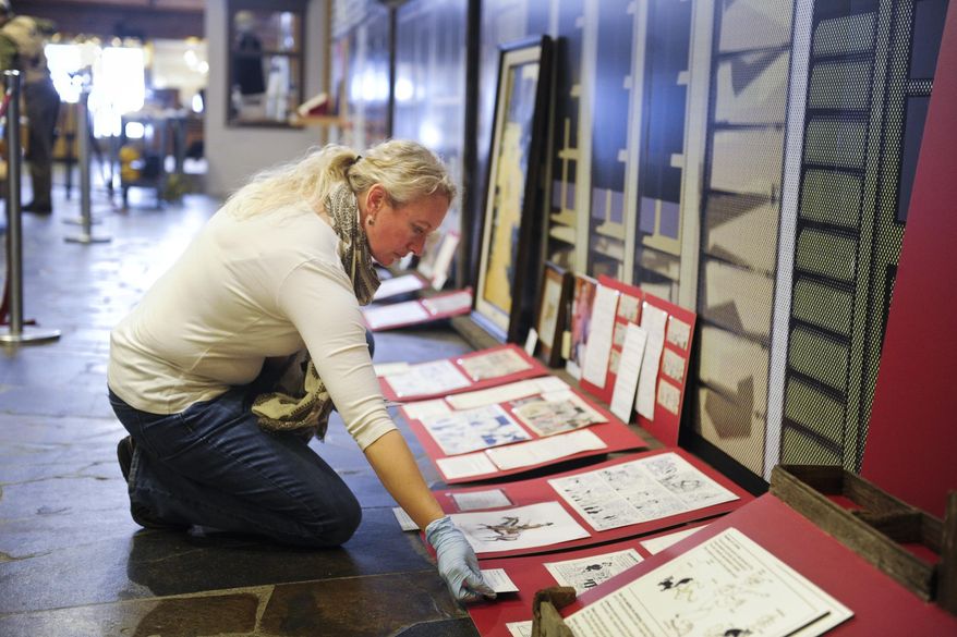 In this Friday, Jan. 15, 2016 photo, Montana Historical Society curator Amanda Streeter Trum adds I.D. tags to pieces in the upcoming exhibition on the work of Montana cartoonist Stan Lynde in Helena, Mont. "From the Heart: Stan Lynde's Comic Creations," will open Thursday, Jan. 21 at the historical society. (Thom Bridge/Independent Record via AP) MANDATORY CREDIT