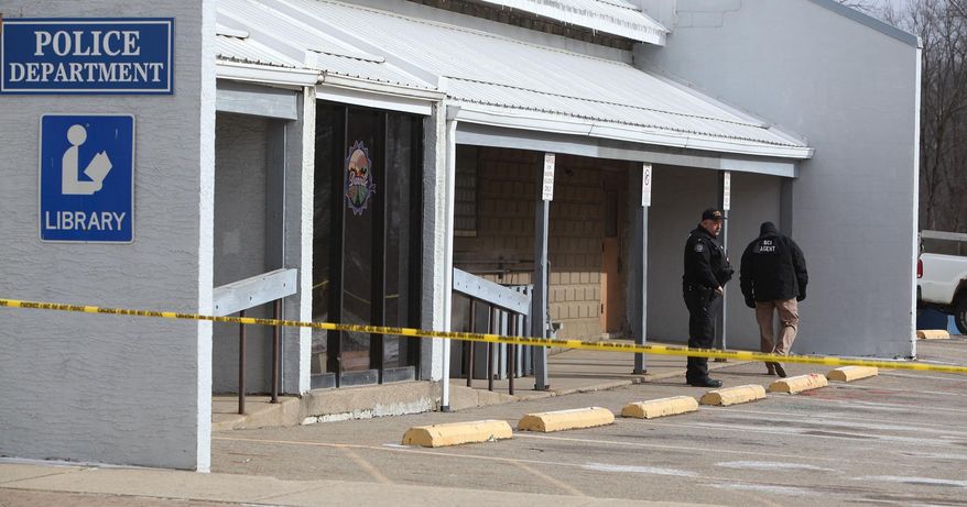 Danville Police Chief Daniel J. Weckessel, left, looks over the police station parking lot where Danville Officer Thomas Cottrell was gunned down Sunday night, Monday, Jan. 18, 2016 in Danville, Ohio. A man whose ex-girlfriend reported that he was armed and looking to kill police was in custody on Monday suspected in the death of Cottrell. (Doral Chenoweth III/Columbus Dispatch via AP)