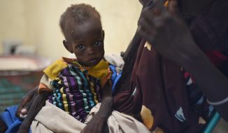 Nyagoah Taka Gatluak, a severely malnourished one-year-old child, sits on her mother&#39;s lap in the Doctors Without Borders clinic in Leer town, South Sudan on Dec. 15. Leer is experiencing famine conditions. (Associated Press)