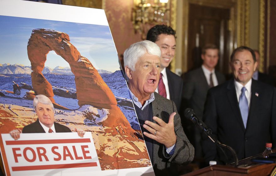 Rob Bishop, left, R-Utah, holds an image he says is misleading and was created by critics of his public lands proposal while speaking during a news conference, as Rep. Jason Chaffetz, center, R-Utah, and Utah Gov. Gary Herbert, right, looks on Wednesday, Jan. 20, 2016, at the Utah State Capitol, in Salt Lake City. The two Utah congressman have unveiled a draft of their plan to protect 4 million acres of Utah land in exchange for freeing up more than 1 million acres for recreation and oil and gas development. (AP Photo/Rick Bowmer)