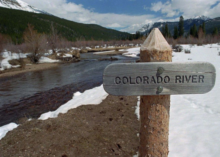 File- In this May 1, 1997 file photograph, sign marks the Colorado River as it flows past the Never Summer Mountains in Rocky Mountain National Park near the town of Grand Lake, Colo. Snowpack in the mountains and valleys that feed the upper Colorado River is slightly above the long-term average, which is welcome news in the drought-stricken Southwest. (AP Photo/David Zalubowski, File)