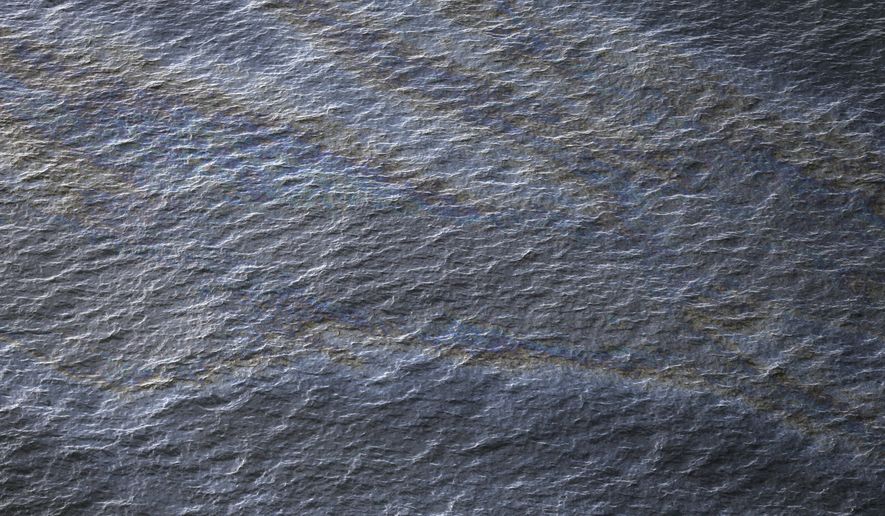 FILE - This March 31, 2015 file photo shows an oil sheen drifting from the site of the former Taylor Energy oil rig in the Gulf of Mexico, off the coast of Louisiana. Taylor Energy President William Pecue on Wednesday, Jan. 20, 2016, told a gathering of industry experts and environmental advocates in Baton Rouge the decade-old oil leak that could last for another century was caused by an "act of God" during a hurricane. (AP Photo/Gerald Herbert, File)