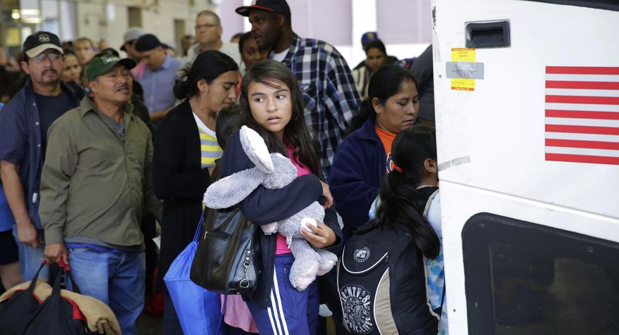 FILE - In this Tuesday, July 7, 2015, file photo, immigrants from El Salvador and Guatemala who entered the country illegally board a bus after they were released from a family detention center in San Antonio. With tens of thousands of Central American families arriving on the U.S.-Mexico border in the last two years, federal authorities have crafted a new plan to try to encourage more of them to show up for immigration court. Starting on Thursday, Jan. 21, as many as 800 families who pass an initial asylum screening can join the program in Los Angeles, New York, Washington, Chicago and Miami. Case workers will be assigned to help them with daily tasks such as finding transportation to immigration court and enrolling their children in school. (AP Photo/Eric Gay, File)