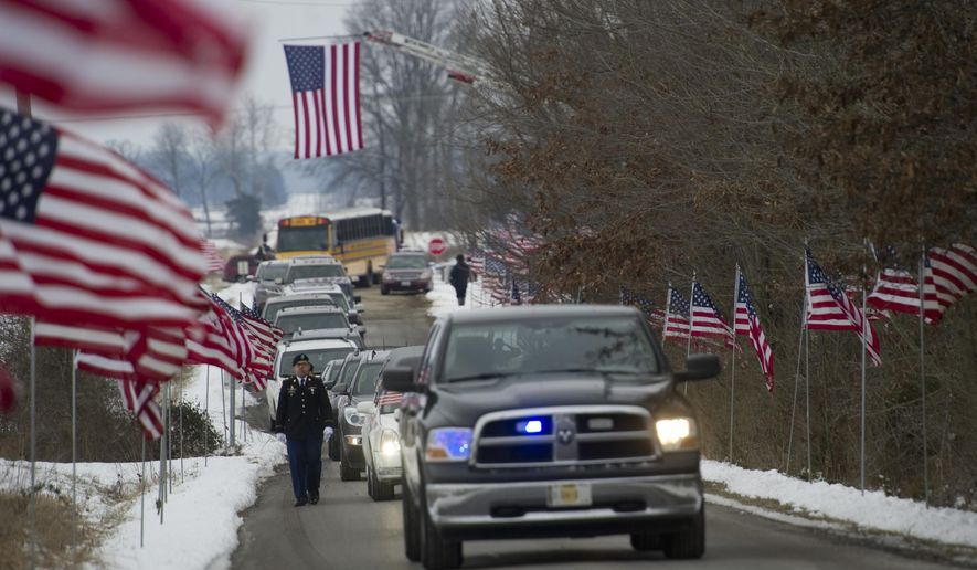 A procession to Little Prairie Cemetery in Albion, Ill., carries Pfc. Kenneth L. Cunningham's remains Thursday afternoon, Jan. 21, 2016. Hundreds of people lined the streets as a hearse went through the southern Illinois city of Albion carrying the remains of Cunningham, an airman listed as missing in action during the Vietnam War. (Denny Simmons/Evansville Courier & Press via AP) MANDATORY CREDIT