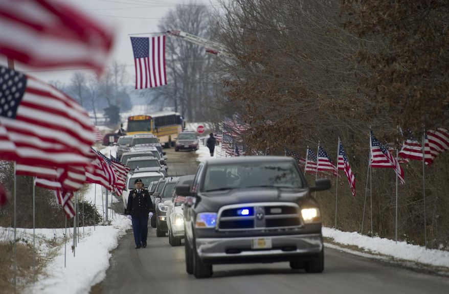 A procession to Little Prairie Cemetery in Albion, Ill., carries Pfc. Kenneth L. Cunningham's remains Thursday afternoon, Jan. 21, 2016. Hundreds of people lined the streets as a hearse went through the southern Illinois city of Albion carrying the remains of Cunningham, an airman listed as missing in action during the Vietnam War. (Denny Simmons/Evansville Courier & Press via AP) MANDATORY CREDIT
