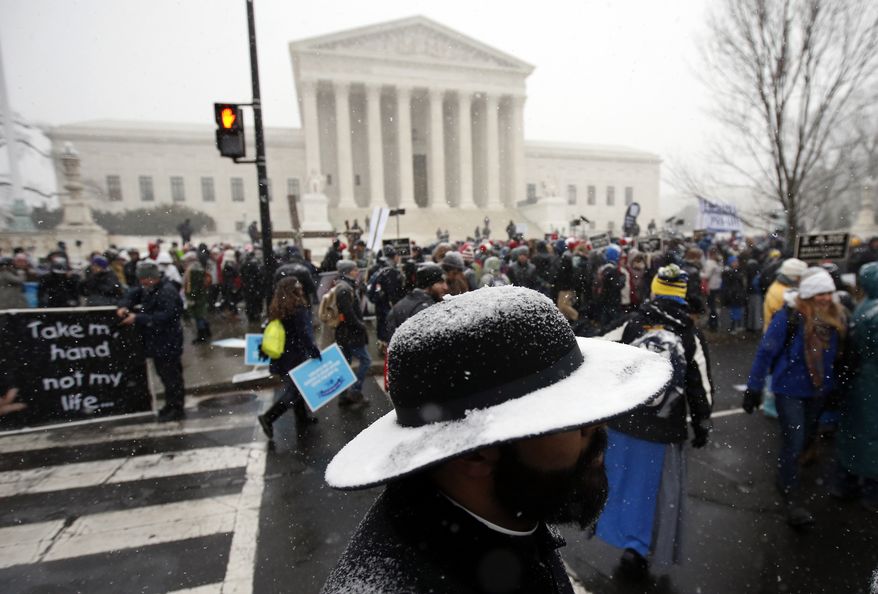Snow covers the hat of Father Jack Soler of the New York borough of Staten Island during the March for Life 2016, in front of the U.S. Supreme Court, Friday, Jan. 22, 2016 in Washington, during the annual rally on the anniversary of 1973 'Roe v. Wade' U.S. Supreme Court decision legalizing abortion. (AP Photo/Alex Brandon)