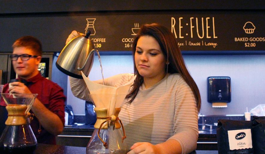 In a photo taken Jan. 14, 2016, Sierra Hauch, 16, a sophomore at iCademy Global, pours hot water over coffee grounds at Re:fuel, a new student-run and operated coffee shop at the school building in Zeeland, Mich. Re:Fuel, a student-designed and operated coffee shop at a Zeeland charter school, is now open for business. Students at the school have been creating a business plan for the shop for at least the past year. In May 2015, a group of high school students traveled to Honduras to learn more about the economy of coffee _ and how important it is to the local growers that they be paid fairly for their hard work. (Amy Biolchini/The Holland Sentinel via AP)