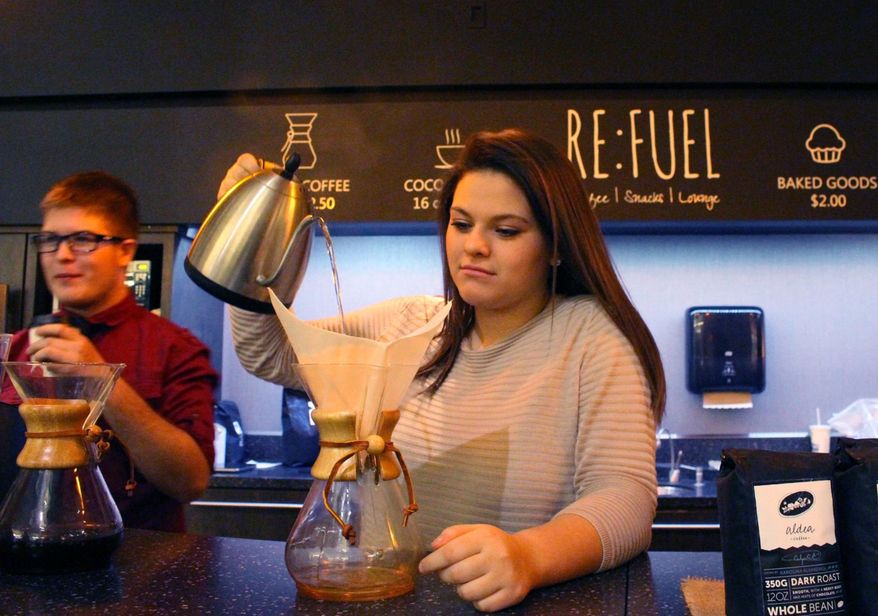 In a photo taken Jan. 14, 2016, Sierra Hauch, 16, a sophomore at iCademy Global, pours hot water over coffee grounds at Re:fuel, a new student-run and operated coffee shop at the school building in Zeeland, Mich. Re:Fuel, a student-designed and operated coffee shop at a Zeeland charter school, is now open for business. Students at the school have been creating a business plan for the shop for at least the past year. In May 2015, a group of high school students traveled to Honduras to learn more about the economy of coffee _ and how important it is to the local growers that they be paid fairly for their hard work. (Amy Biolchini/The Holland Sentinel via AP)