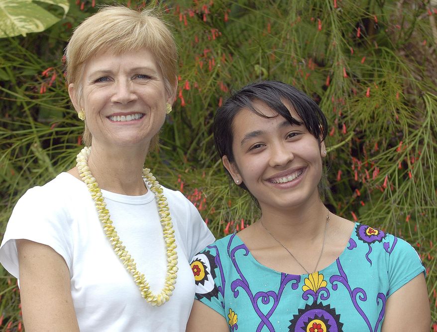 ADVANCE FOR WEEKEND JAN. 23-24, 2016 AND THEREAFTER - In this Jan. 15, 2016 photo host mother Pamela Wang, left, poses with exchange student Mehrangez Rahmatova in Kealakekua, Hawaii. Rahmatova, 19, was on the Big Island in 2012 as a student at Konawaena High School. Living in the United States has been a major shift from the post-Soviet, largely mono-cultural, and patriarchal culture of her homeland, Tajikistan. (Laura Shimabuku/West Hawaii Today via AP)