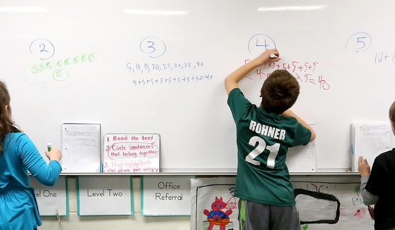 In this Monday, Dec. 14, 2015, file photo, second-graders write out their math solutions at Sageville Elementary School in Sageville, Iowa. Common Core standards for mathematics expect students to conceptually understand math. Multiple strategies, versus a single algorithm, are taught. Forty-two states, including Iowa, Wisconsin and Illinois, have adopted the standards designed to prepare K-12 students for higher education and the professional world. (Jessica Reilly/Telegraph Herald via AP) ** FILE **