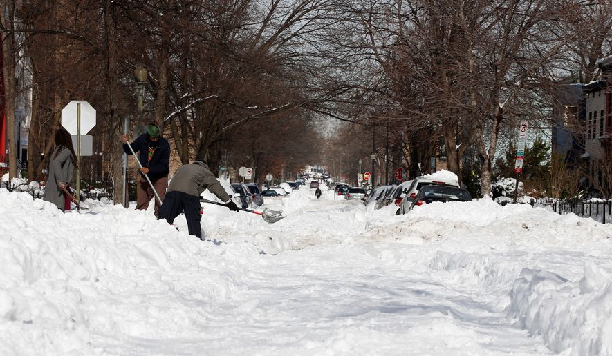 Michael Dee (right) and others work to clear the intersection of Eighth and Q streets in the District on Monday. Neither street appeared to have been plowed. Officials said snow crews were clearing entire neighborhoods before moving on. (Associated Press)