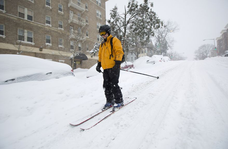 Bryan Gold skis down 13th Street in the Columbia Heights neighborhood of Washington, Saturday, Jan. 23, 2016, as he heads to a friends home to check up on them. Millions of people awoke Saturday to heavy snow outside their doorsteps, strong winds that threatened to increase through the weekend, and largely empty roads as residents from the South to the Northeast heeded warnings to hunker down inside while a mammoth storm barreled across a large swath of the country. (AP Photo/Pablo Martinez Monsivais)