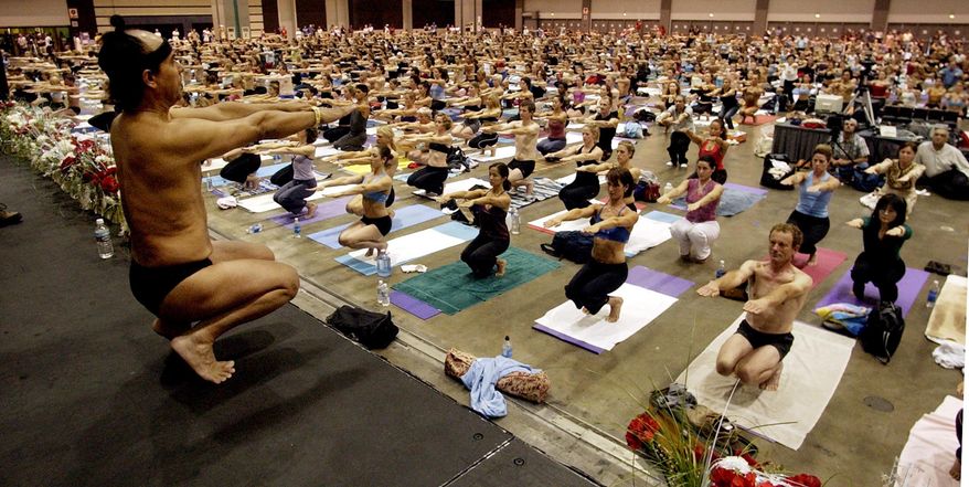 In this Sept. 27, 2003, file photo, Bikram Choudhury, front, founder of the Yoga College of India and creator and producer of Yoga Expo 2003, leads what organizers hope will be the world's largest yoga class at the Expo at the Los Angeles Convention Center. (AP Photo/Reed Saxon, File)