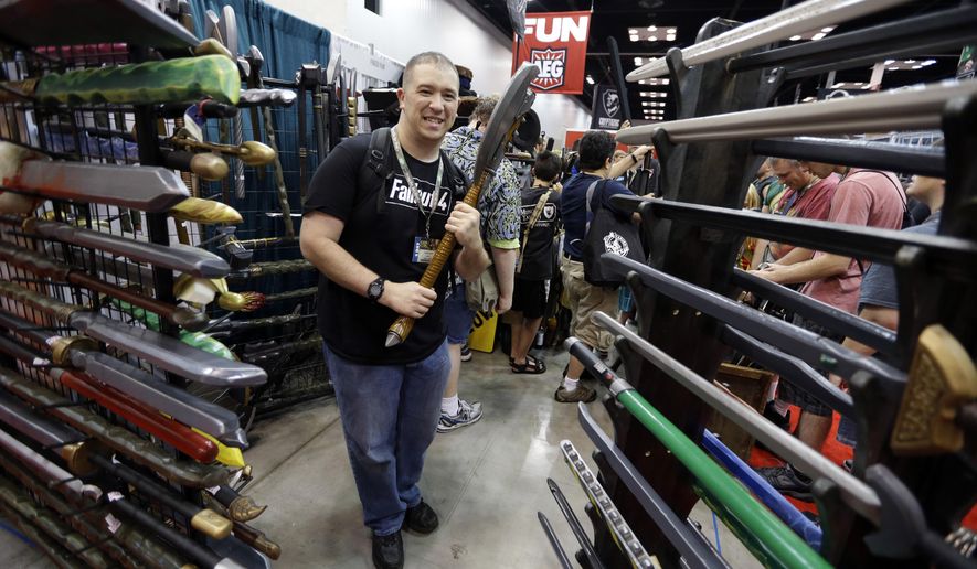 In this July 30, 2015 photo, Daniel Lavely, of Vincennes, Ind., checks out a display of replica weapons in the exhibition hall of the Gen Con gaming convention in Indianapolis. Tourism officials say Indiana may have lost as much as $60 million in revenue after a dozen conventions picked cities other than Indianapolis amid the uproar over the state’s controversial religious objections law. The state Senate is scheduled to take up measures addressing LGBT rights on Wednesday. (AP Photo/Michael Conroy)