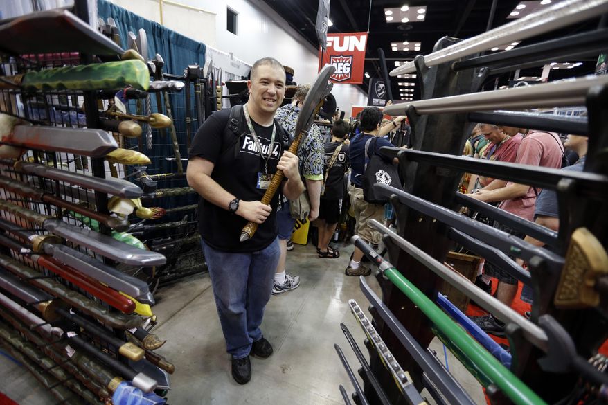 In this July 30, 2015 photo, Daniel Lavely, of Vincennes, Ind., checks out a display of replica weapons in the exhibition hall of the Gen Con gaming convention in Indianapolis. Tourism officials say Indiana may have lost as much as $60 million in revenue after a dozen conventions picked cities other than Indianapolis amid the uproar over the state’s controversial religious objections law. The state Senate is scheduled to take up measures addressing LGBT rights on Wednesday. (AP Photo/Michael Conroy)