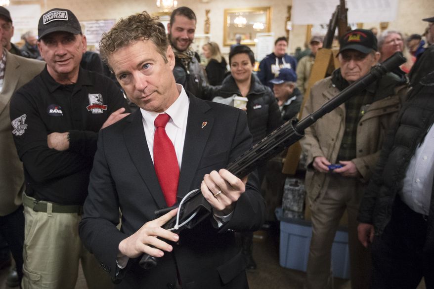 Republican presidential candidate, Sen. Rand Paul, R-Ky.,  handles a AR-15 style rifle as he meets with customers during a campaign stop at a gun show at Bektash Shrine Center, Saturday, Jan. 23, 2016, in Concord. (AP Photo/John Minchillo)