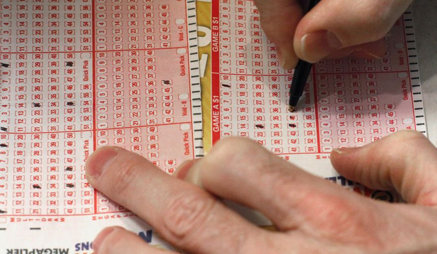 A customer fills out a lottery form for the Mega Millions drawing in Chicago. (Associated Press)
