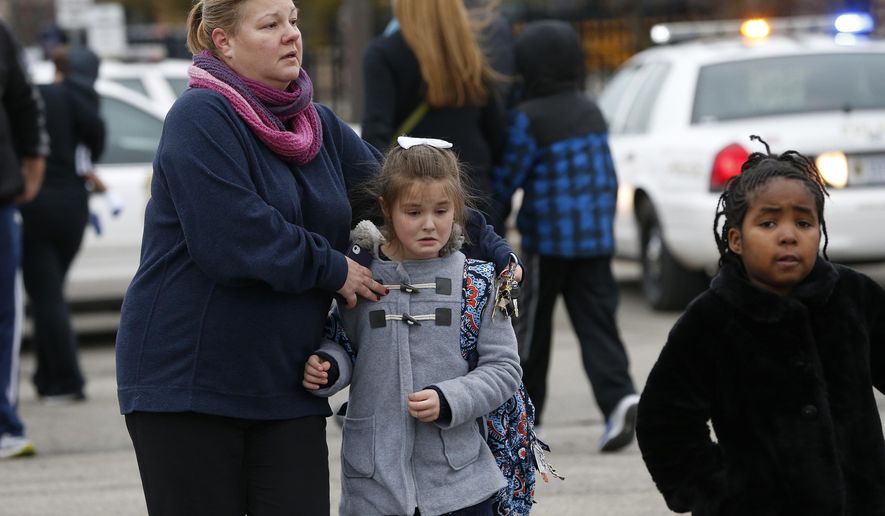 Students at Amy Beverland Elementary School are picked up after school after a bus accident in Indianapolis on Tuesday, Jan. 26, 2016. Authorities said an adult was killed and two children were seriously injured when a bus waiting outside the elementary school suddenly lurched forward and struck them. (Mykal McEldowney/The Indianapolis Star via AP) MANDATORY CREDIT
