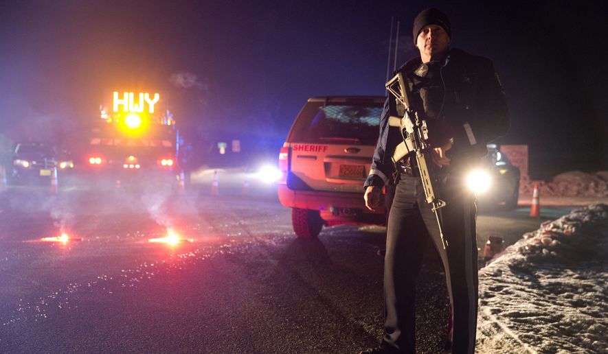 Sgt. Tom Hutchison stands in front of an Oregon State Police roadblock on Highway 395 on Tuesday, Jan. 26, 2016 between John Day and Burns, Ore. The FBI on Tuesday arrested the leaders of an armed group that has occupied a federal wildlife refuge in eastern Oregon for the past three weeks. (Dave Killen/The Oregonian via AP)
