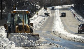 Crews clear the Rivermont Avenue Bridge of snow on Sunday, Jan. 24, 2016 in Lynchburg, Va. Despite the break in the weather, the Virginia Department of Transportation is echoing the advice of Gov. Terry McAuliffe: stay off the roads. (Jay Westcott/The News &amp; Advance via AP)