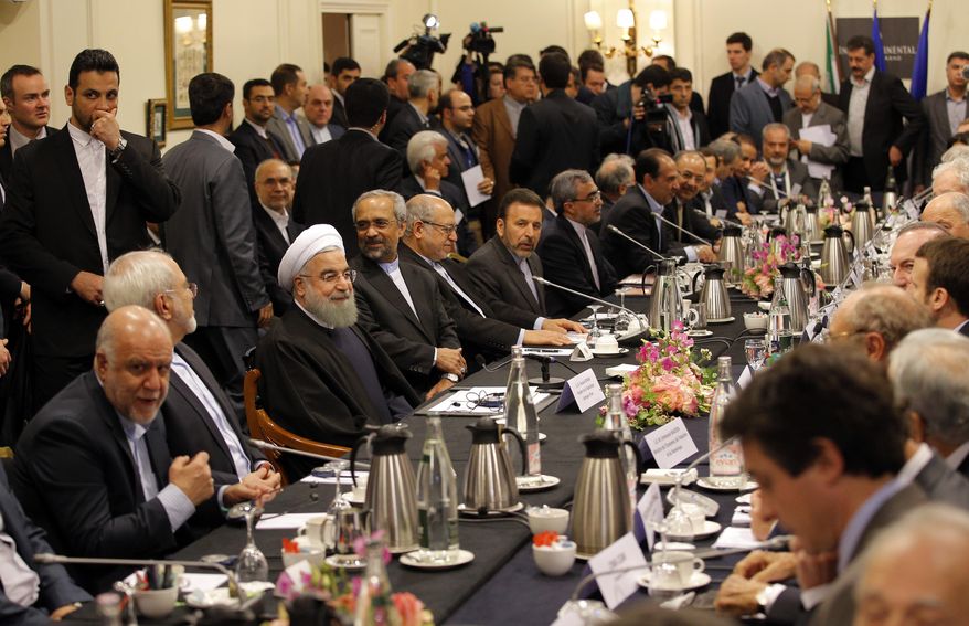 Iranian President Hassan Rouhani, third left seated, attends a meeting with French Economy Minister Emmanuel Macron and French business leaders in Paris, Wednesday, Jan. 27, 2016. Rouhani says his first visit to Europe since the nuclear accord was signed has proven that there are "great possibilities" for economic, academic, scientific and cultural cooperation and that "today we are in a win-win situation" after years of mutual losses due to sanctions. (AP Photo/Christophe Ena)