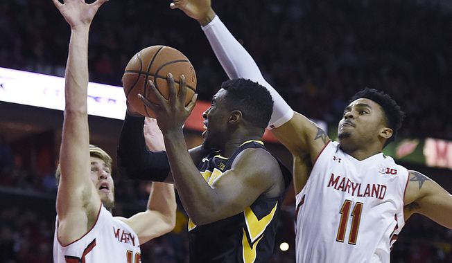 Maryland&#x27;s Jake Layman, left, and Jared Nickens, right, defend against Iowa&#x27;s Anthony Clemmons, center, in the first half of an NCAA college basketball game, Thursday, Jan. 28, 2016, in College Park, Md. (AP Photo/Gail Burton)