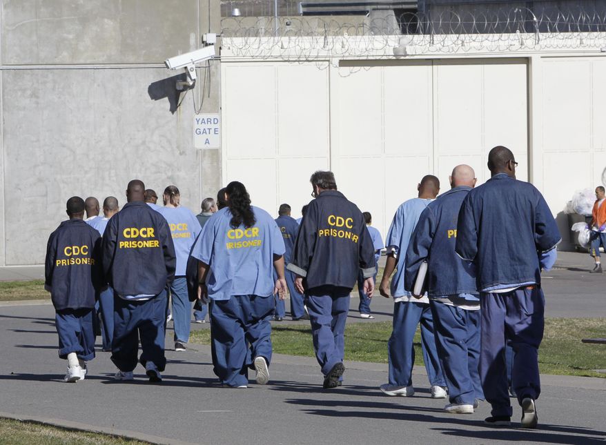 FILE - In this Feb. 26, 2013, file photo, inmates walk through the exercise yard at California State Prison Sacramento, near Folsom, Calif. Gov. Jerry Brown's latest attempt to reduce the state prison population is a ballot initiative unveiled Wednesday, Jan. 27, 2016, that aims to free certain felons earlier and have fewer juveniles tried as adults. (AP Photo/Rich Pedroncelli, File)