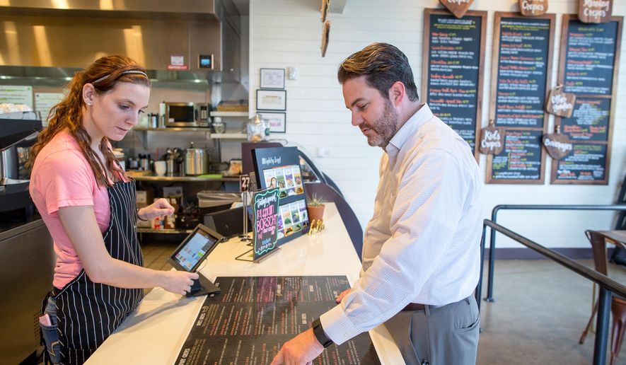 ADVANCE FOR USE MONDAY, FEB. 1 - In this photo taken Jan. 14, 2016, Kristen Black, left, looks on as Jeff Kendall points out his order at Crepe Crazy, a deaf-owned and operated crepery in Austin, Texas. (Tom McCarthy Jr./Austin American-Statesman via AP) AUSTIN CHRONICLE OUT, COMMUNITY IMPACT OUT, INTERNET AND TV MUST CREDIT PHOTOGRAPHER AND STATESMAN.COM, MAGS OUT; MANDATORY CREDIT
