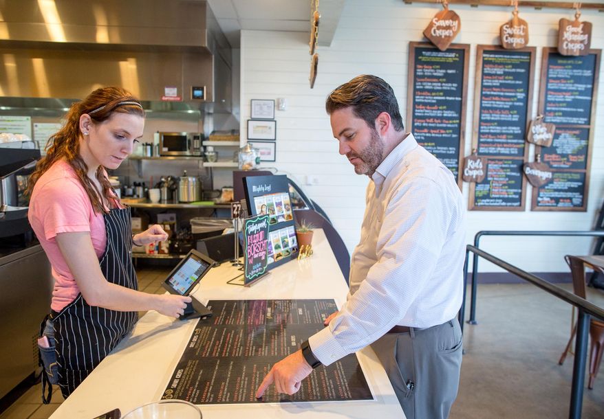 ADVANCE FOR USE MONDAY, FEB. 1 - In this photo taken Jan. 14, 2016, Kristen Black, left, looks on as Jeff Kendall points out his order at Crepe Crazy, a deaf-owned and operated crepery in Austin, Texas. (Tom McCarthy Jr./Austin American-Statesman via AP) AUSTIN CHRONICLE OUT, COMMUNITY IMPACT OUT, INTERNET AND TV MUST CREDIT PHOTOGRAPHER AND STATESMAN.COM, MAGS OUT; MANDATORY CREDIT