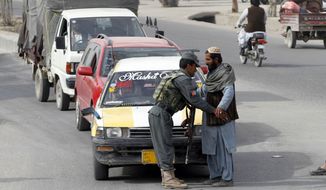 An Afghan policeman searches a passenger at a checkpoint in Kandahar, Afghanistan, Tuesday, Jan. 26, 2016. An Afghan official says that a policeman has turned his weapon on fellow police officers at a checkpoint in the country&#39;s south, killing 10 policemen. (AP Photo/Allauddin Khan)
