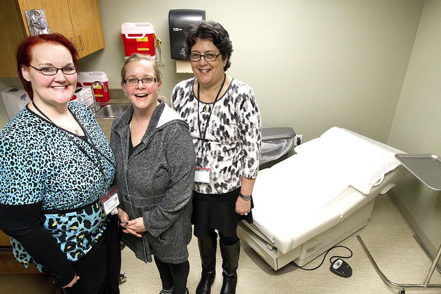 ADVANCE FOR USE MONDAY, FEB. 1 - In this recent photo, from left, Jennifer Wisniewski, Krista Bedells and Dawn Bergman pose for a picture in one of the exam rooms at the integrated clinic at Northern Lakes Community Mental Health in Traverse City, Mich.. Wisniewski and Bedells are nurses and Bergman is a patient and peer-support specialist. (Tessa Lighty/Traverse City Record-Eagle via AP) MANDATORY CREDIT