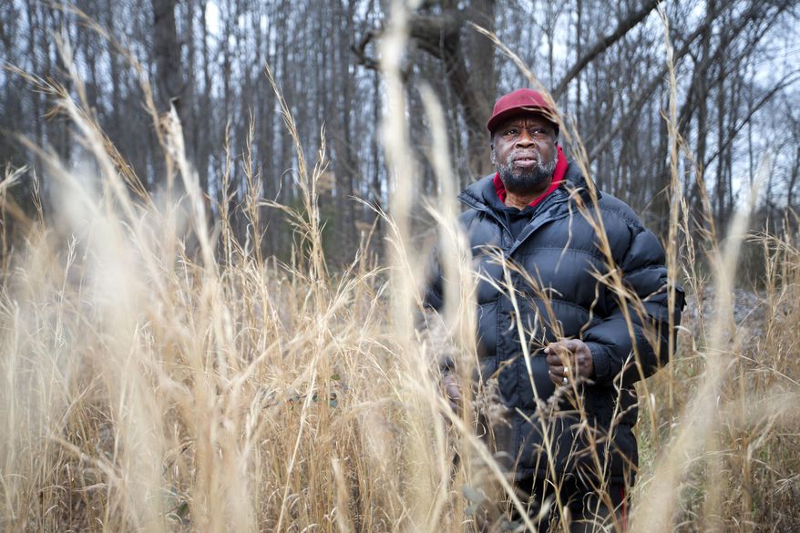 In this Friday, Jan. 15, 2016 photo, John W. Jeffries stands on a piece of land in Greensboro, N.C. where he once hunted and fished as a boy. Jeffries and his sister, Barbara, own 9.3 acres, the last piece of 86 acres owned by these direct descendants of Daniel Jeffries, who was a slave born in Caswell County but earned enough money after emancipation to buy land in Guilford County. But now he can't even get to the property because he doesn't own any access through the property that surrounds his parcel. (AP Photo/News & Record, Andrew Krech)