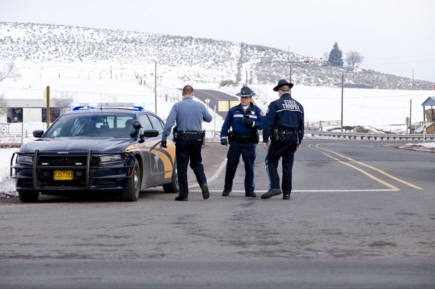 Oregon State Police man a roadblock at the intersection of highways 395 and 20 outside of Burns, Ore., Wednesday morning, Jan. 27, 2016. Authorities were restricting access on Wednesday to the Malheur National Wildlife Refuge headquarters being occupied by an armed group after one of the occupiers was killed during a traffic stop and eight more, including the group's leader Ammon Bundy, were arrested. (Dave Killen/The Oregonian via AP)