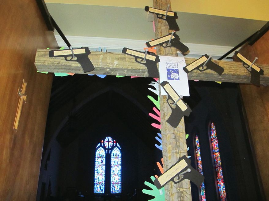 A cross with cutouts of handguns and the names of the nine victims of the Charleston church shootings stands at the door to the chapel at Washington Street United Methodist Church in Columbia, S.C., on Friday, Jan. 29, 2016. Parishioners attending a Stand-Up Sunday service at the chapel on Jan. 31 will pass under the cross. An estimated 1,300 congregations of all denominations in South Carolina are participating in the Stand-Up Sunday to draw attention to the national epidemic of gun violence and seek tighter gun laws while respecting people's rights to own guns. (AP Photo/Bruce Smith)