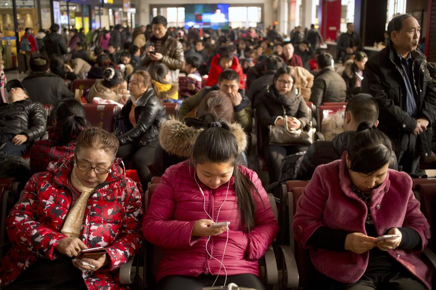 Passengers use their smartphones as they sit in a waiting room at the Beijing Railway Station in Beijing, Saturday, Jan. 30, 2016. China's peak travel season is kicking into high gear as hundreds of millions of people return home for Spring Festival celebrations or head for vacation destinations. According to the Ministry of transport, Chinese travelers are expected to make 2.9 billion trips during the 40-day period between Jan. 21 and March 3, with the majority of those trips falling in the weeks around the Feb. 8 Lunar New Year. (AP Photo/Mark Schiefelbein)