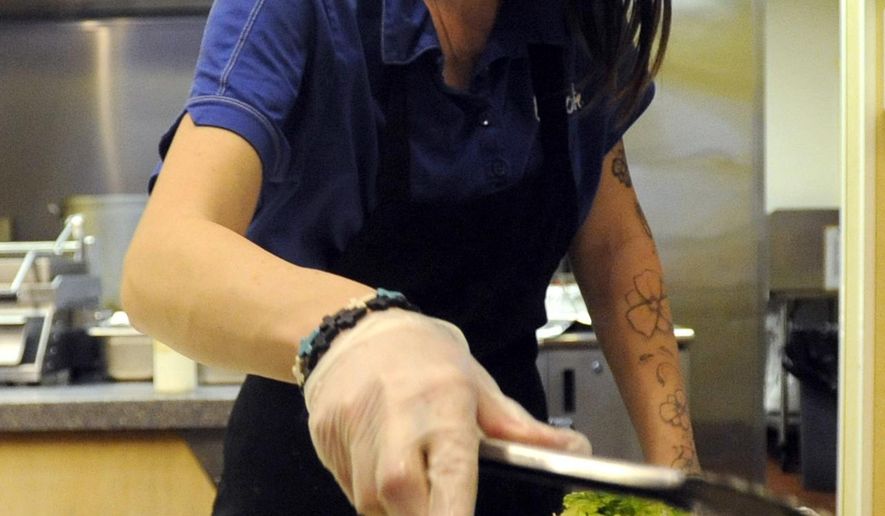 FOR RELEASE SATURDAY, JANUARY 30, 2016, AT 12:01 A.M. MST. - Christine Reyes carefully grabs some lettuce for a burrito on Wednesday at the Qdoba off of 11th Avenue in Greeley, Colo. Qdoba is experimenting by paying employees $11 an hour for 3 months to create more stability in their work force. (Joshua Polson/The Greeley Tribune via AP)