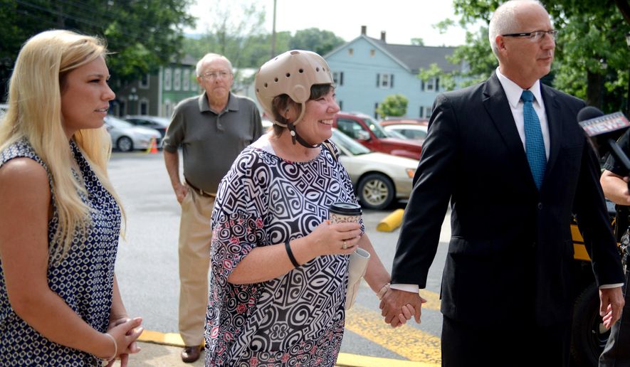 FILE - In this June 23, 2015, file photo, Sharon and Randy Budd, right, along with their daughter Kaylee, left, enter the Union County Courthouse in Lewisburg, Pa. Sharon Budd, a middle-school teacher who lives near Akron, Ohio, suffered head injuries when a rock dropped from an overpass crashed through the windshield of her family's car in Pennsylvania in July 2014. Thanks in part to efforts by Sharon Budd and her family, a change in Ohio Department of Transportation rules took effect Friday, Jan. 1, 2016, that requires new or rehabbed bridges over most busy roadways in Ohio to have fencing to deter vandals. (Amanda August/The Daily Item via AP, File)
