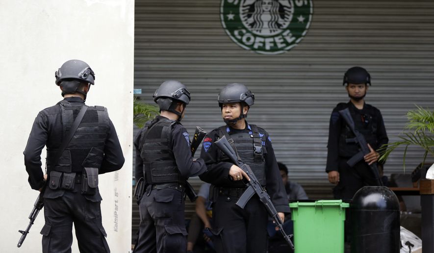 Indonesian police officers guard a Starbucks cafe in Jakarta, Indonesia, on Jan. 16, two days after it was a target of a suicide bombing attack funded by the Islamic State. (Associated Press) **FILE**