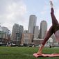 In this Aug. 25, 2015, photo, Sara DiVello sits in a modified lotus pose in the Financial District of Boston. DiVello, who stayed for years at a financial services company in Boston despite the fact she had an abusive boss, is now a yoga teacher. (AP Photo/Charles Krupa)
